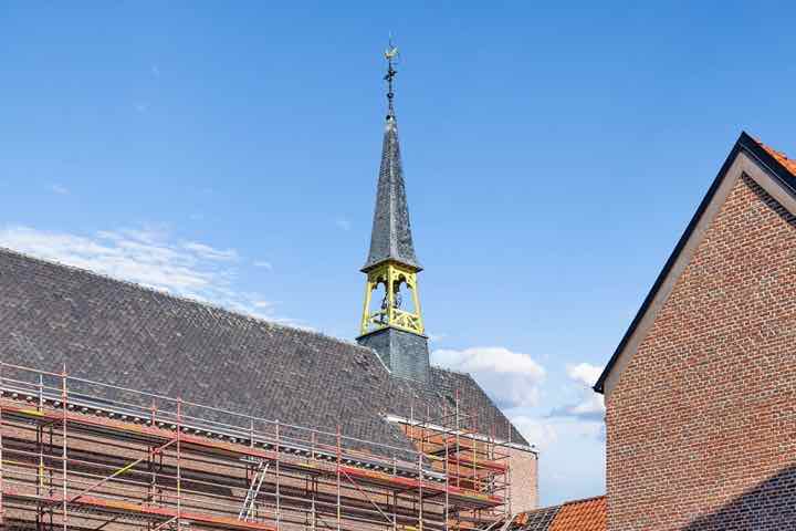 De kerktoren in de steigers